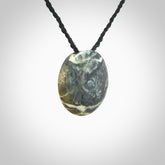 This piece is a small oval round, disc pendant hand carved in New Zealand jade.
